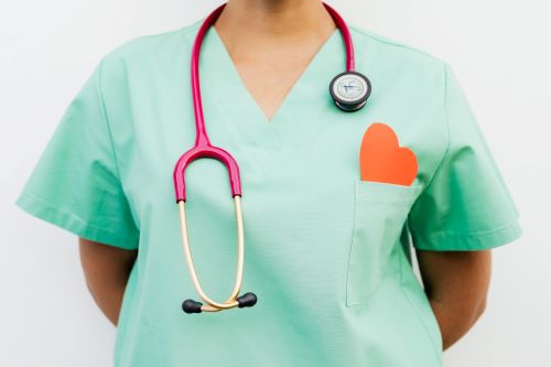 A doctor with a stethescope and a paper heart.