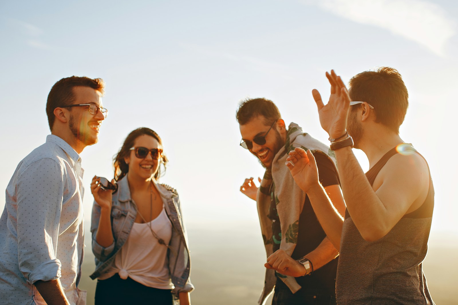 three men and one woman with employees health insurance laughing during daytime